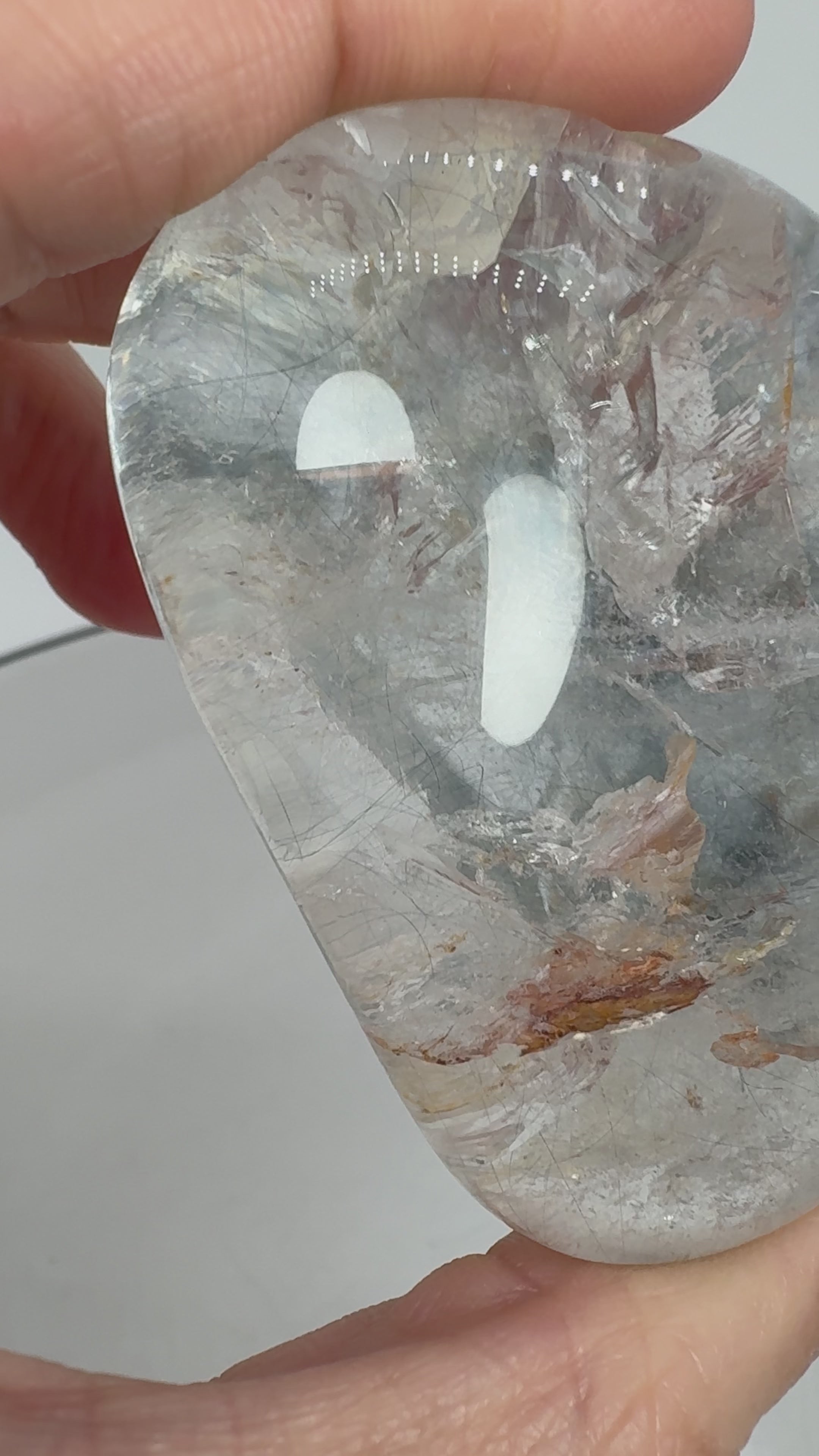 Un pequeño universo natural en el interior del cuarzo. Este palmstone contiene finas agujas de rutilo e inclusiones de aspecto plateado, que crean un paisaje lleno de detalles entre transparencias y delicados matices cálidos.