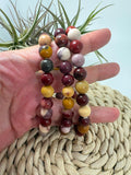 Pulsera elástica de mokaita natural con cuentas de 8 mm. Una joya de tonos cálidos y variados, asociada al equilibrio, la vitalidad y la confianza.