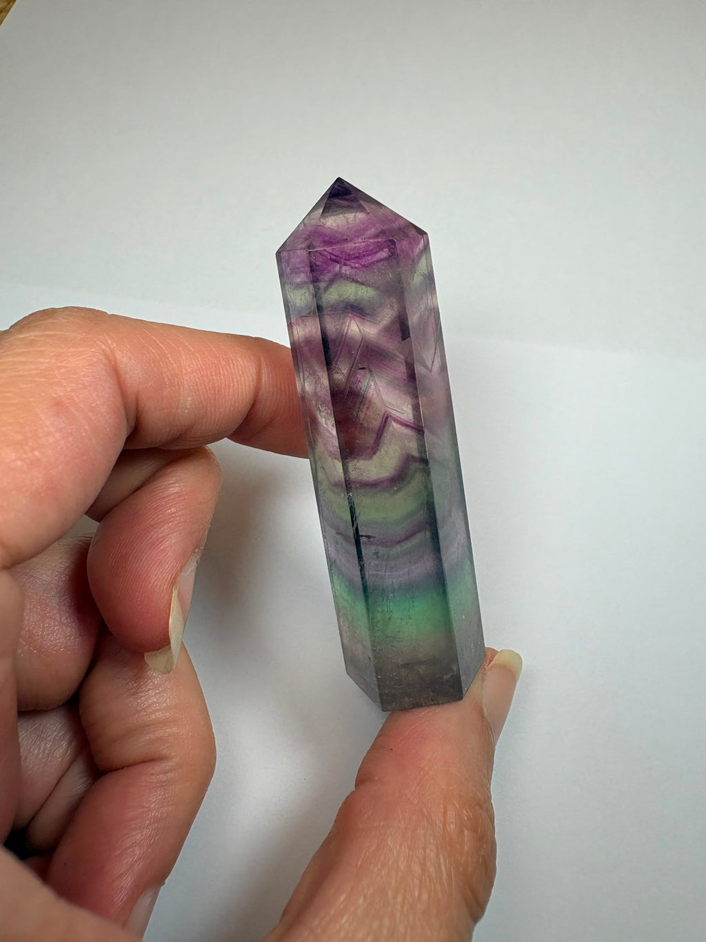 Punta de fluorita arcoíris natural pulida de 6 × 1,5 cm. Pieza única con hermosas bandas de color, ideal para colección, decoración o meditación