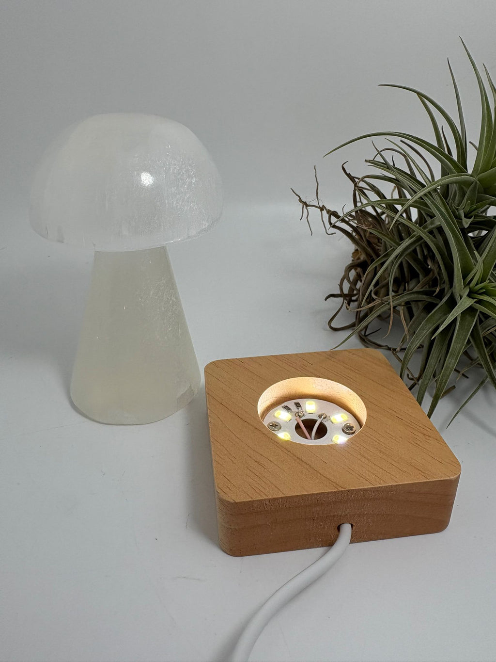 Lámpara usb de selenita natural con base led de madera. Pieza de gran calidad, elegante y luminosa, ideal para decorar y armonizar cualquier espacio.