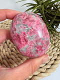 Palmstone de thulita natural de Noruega de 6,1 cm. Piedra asociada al amor, la alegría y la energía del corazón. Pieza única