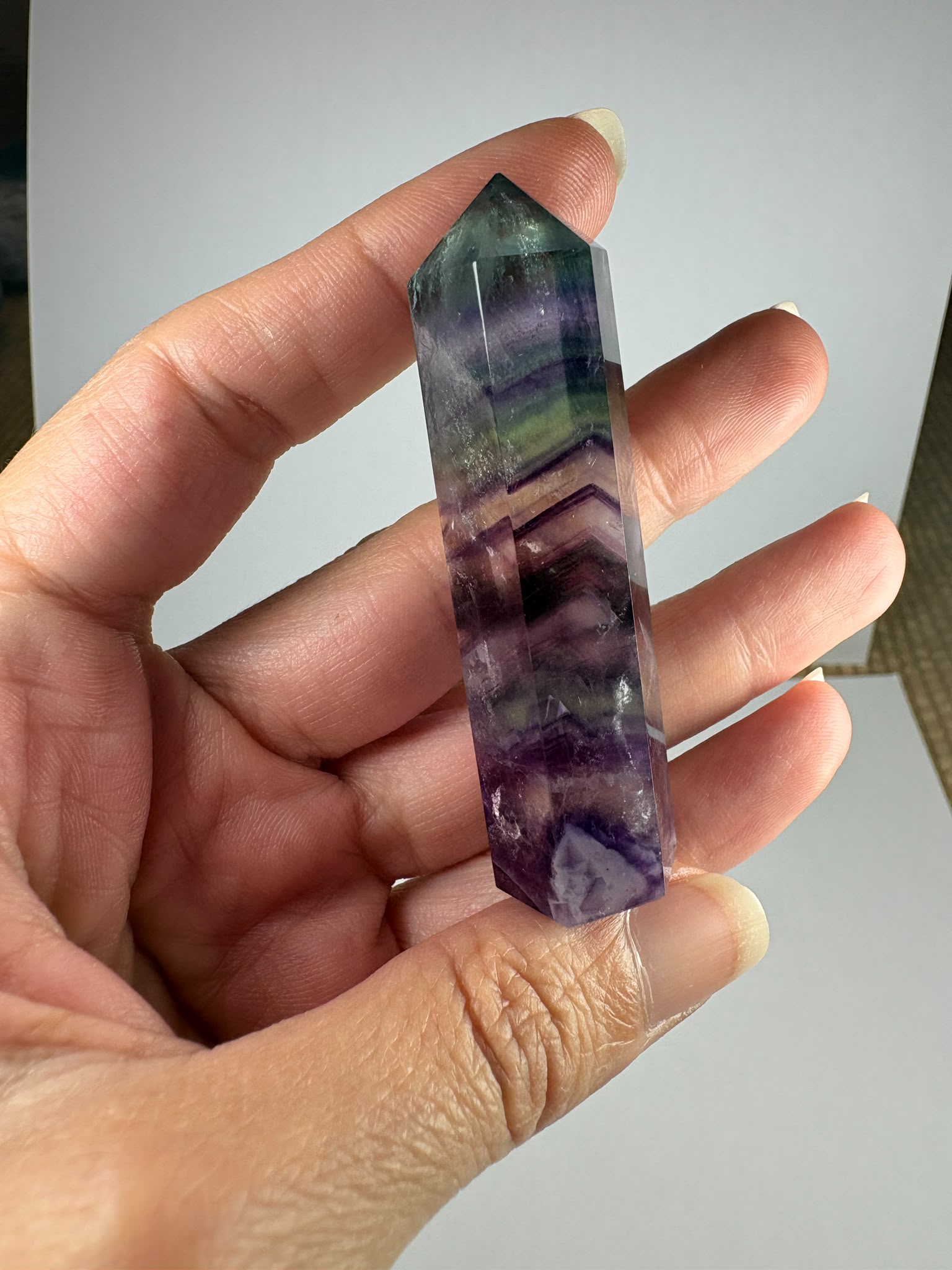 Punta de fluorita arcoíris natural pulida de 6 × 1,5 cm. Pieza única con hermosas bandas de color, ideal para colección, decoración o meditación